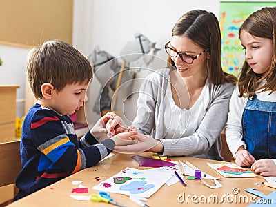 Preschool Teacher with Children at Kindergarten - Creative Art Class Stock Photo