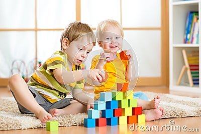 Preschooler children playing with colorful toy blocks. Kid playing with educational wooden toys at kindergarten or day care center Stock Photo