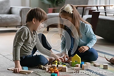 Preschooler children sit on floor playing at home together Stock Photo