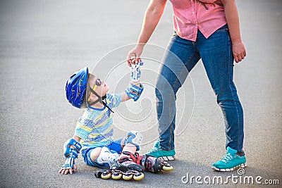 Preschooler falls over while rollerblading with mother in the pa Stock Photo