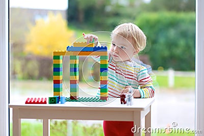 Preschooler girl building from plastic bricks Stock Photo