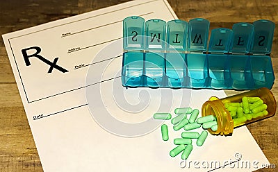 Prescription bottle with green pills, pill minder on RX form Stock Photo