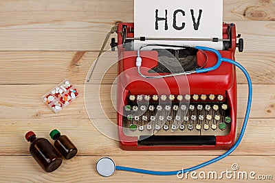 Prescription medicine or medical diagnosis - doctor workplace with blue stethoscope, pills, red typewriter with text HCV Stock Photo