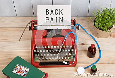 Prescription medicine or medical diagnosis - doctor workplace with stethoscope, pills, typewriter with text Back Pain Stock Photo