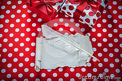 Present box vintage sheet of paper feather on polka-dot red fabr Stock Photo