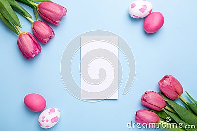 Present card , flowers tulips and easter eggs on a blue background Stock Photo