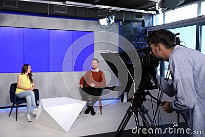 Presenters and video camera operator working. News broadcasting Stock Photo