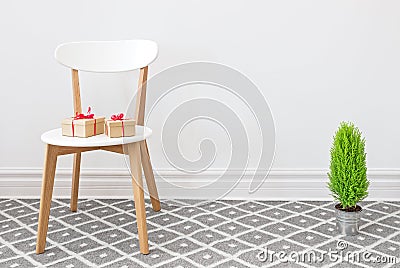 Presents on a white chair, and little green tree Stock Photo