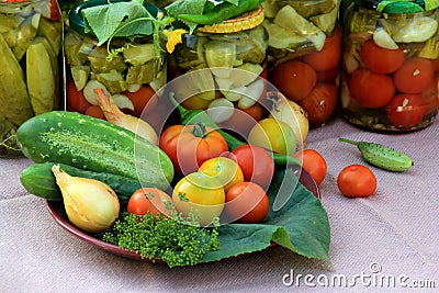 Preserves vegetables in glass jars on the table in summer garden. glass jars with various vegetables Stock Photo