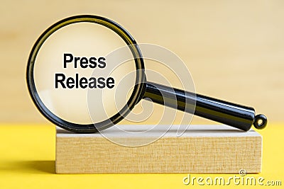 Press Release word through magnifying glass on wooden background Stock Photo