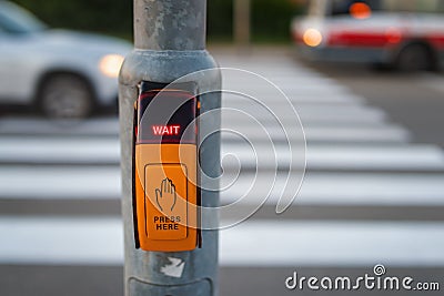 Pressed button for traffic light with wait signal at pedestrian crossing Stock Photo