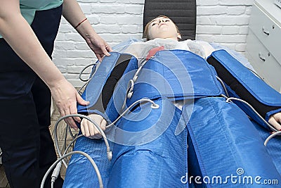 Pressotherapy procedure in a beauty salon. Modern lymphatic drainage massage. Stock Photo