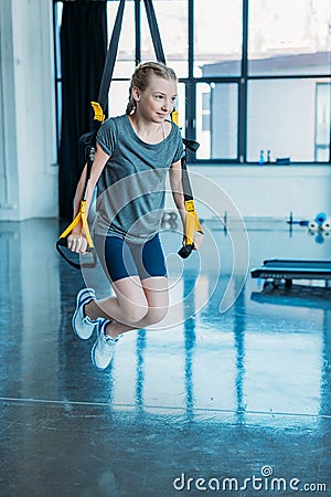 Preteen girl training with resistance bands in fitness class Stock Photo