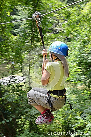 Preteen girl zipping down Stock Photo