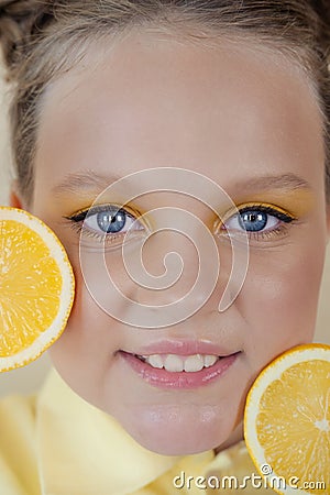 preteenager girl with lemon on yellow background. child with fruit Stock Photo