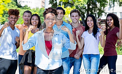 Pretty african american female student with group of cheering young adults Stock Photo