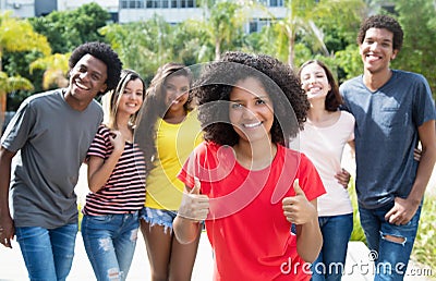 Pretty african american woman showing thumb up with international friends Stock Photo