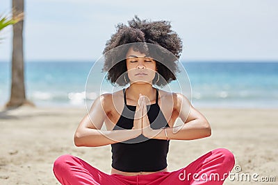 Pretty afro american woman meditating on beach Stock Photo