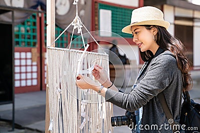 Visitor tying fortune paper on ropes Stock Photo