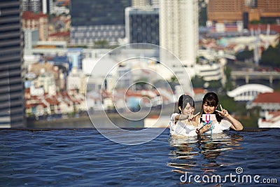 Japanese Girls taking selfies in swiming pool Editorial Stock Photo