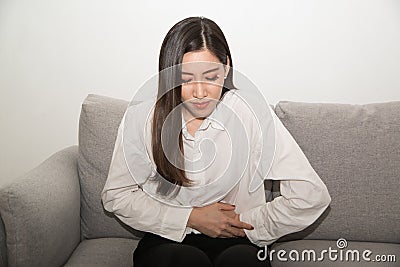 Asian woman having painful stomachache,Female suffering from abdominal pain. Stock Photo