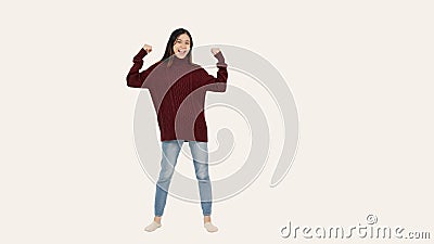 A pretty Asian woman stands against an isolated white background in a strong full-body pose Stock Photo