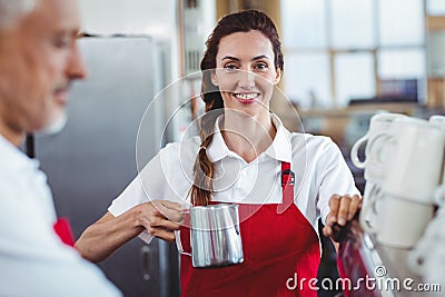 Pretty barista looking at camera and using the coffee machine Stock Photo