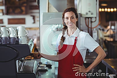 Pretty barista looking at camera and using the coffee machine Stock Photo