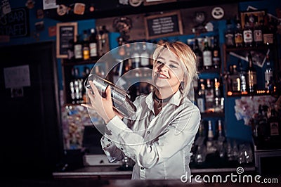 Pretty barmaid decorates colorful concoction in the night club Stock Photo