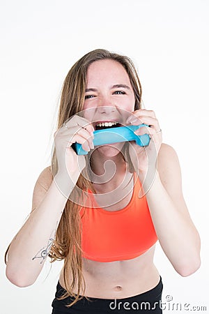 Pretty blond woman bites her workout dumbbell. Stock Photo