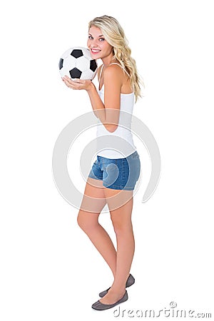 Pretty blonde football fan holding ball Stock Photo