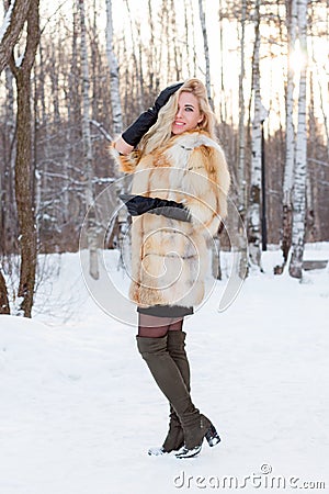 Pretty blonde in fur coat, leather gloves poses outdoor Stock Photo