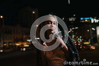 Pretty blonde woman in fancy elegant evening clothes with sequins looking at camera. Stock Photo