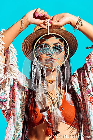 pretty bohemian girl holding dreamcatcher in front of face Stock Photo