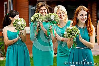 Pretty bridesmaids in mint dresses applaud during the ceremony Stock Photo