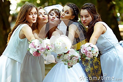 Pretty bridesmaids surround a bride holding wedding bouquets in Stock Photo