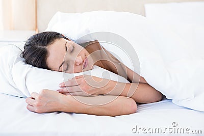 Pretty brunette sleeping on bed Stock Photo