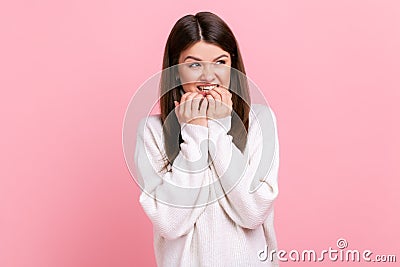 Pretty brunette woman biting nails, being nervous terrified, feeling frightened, anxiety disorder. Stock Photo