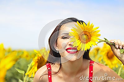 Pretty brunette woman in sunflower field Stock Photo