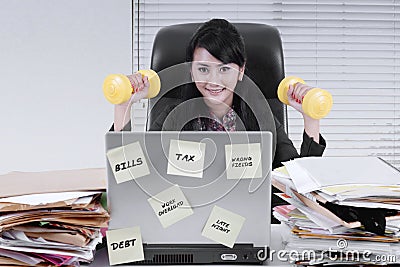 Pretty businesswoman exercising with dumbbells Stock Photo