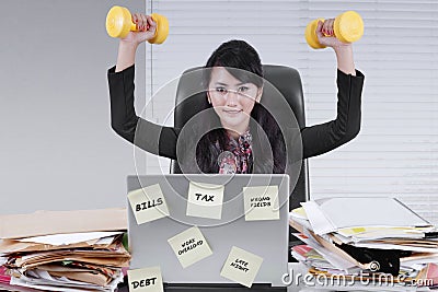 Pretty businesswoman lifting two dumbbells Stock Photo