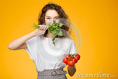 Pretty caucasian girl with curly hair holding vegetables Stock Photo