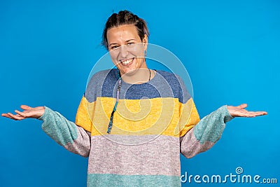 Pretty Caucasian trying to hesitating between two decisions on a blue background - copy space Stock Photo
