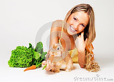 Pretty cheerful girl feeding a rabbit Stock Photo