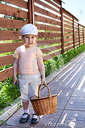 Pretty child with basket walking on house courtyard Stock Photo