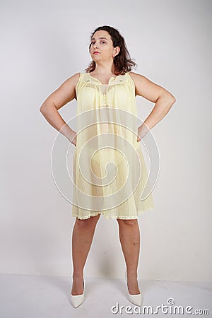 Pretty chubby girl wearing fashionable yellow underwear and loves her body and herself. plump woman in lingerie on white backgroun Stock Photo