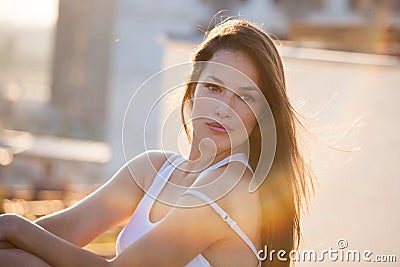 Pretty city girl portrait at sunset backlight at top of building Stock Photo