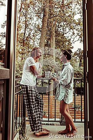 Pretty close couple staying on the balcony and talking to each other Stock Photo