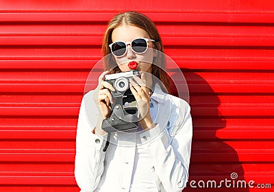 Pretty cool woman with retro camera over red Stock Photo