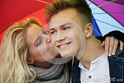 Pretty couple kissing under an umbrella Stock Photo